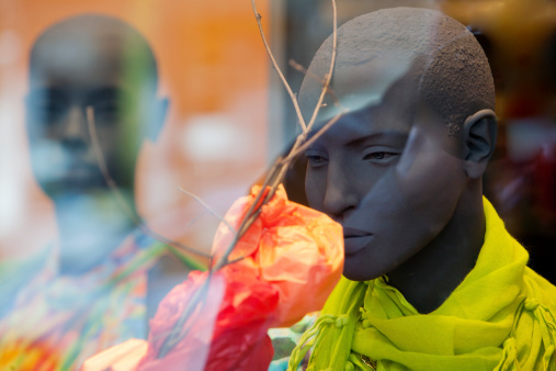 Male mannequin smelling a textile flower in a clothing store