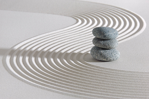 Japan garden with three white stacked stones in white textured sand