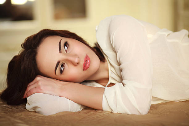istock Pensive young woman lying on bed at home 471996958