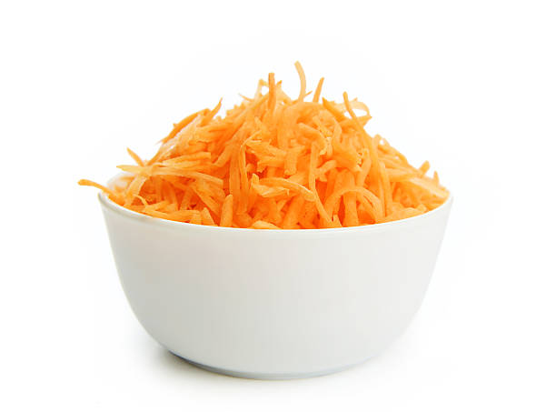 Grated carrots in a cup on white background