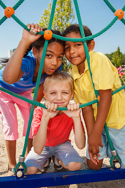 três crianças no parque infantil - playground schoolyard playful playing imagens e fotografias de stock