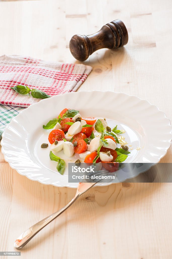 Caprese salad Delicious caprese salad with mozzarella, cherry tomatos, basil and capers. Basil Stock Photo