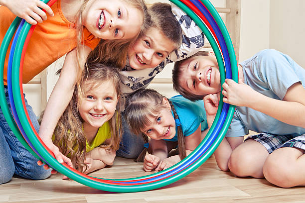Five cheerful kids Five cheerful kids looking through hula hoops playful stock pictures, royalty-free photos & images