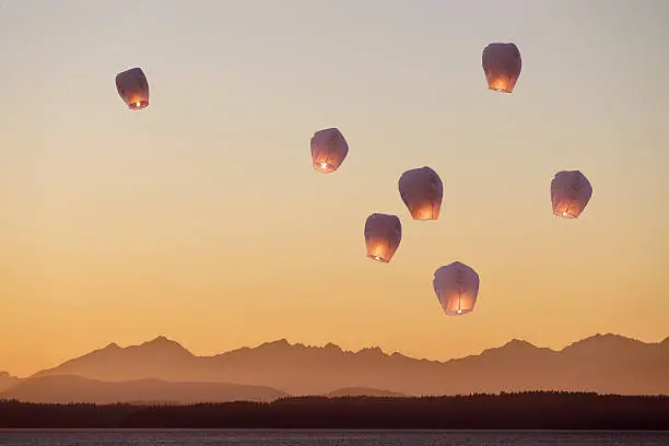 A group of flying lanterns being released into the nightsky