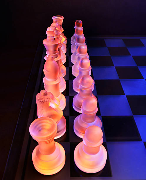 glas schach auf der schachbrett-hell blau und orange licht - armed forces black yellow chess pawn stock-fotos und bilder