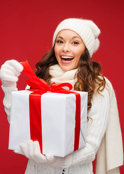 istock smiling woman in white clothes with gift box 472003109