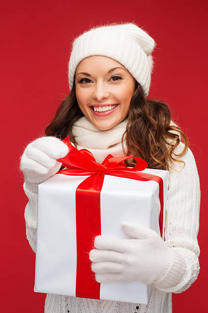 istock smiling woman in white clothes with gift box 472003197