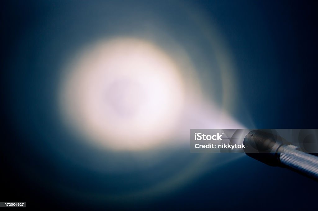 A small pocket flash light shining on the wall focused glowing pocket torch light Flashlight Stock Photo