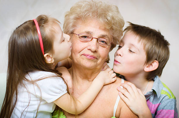 enkelkinder küssen großmutter - glen little stock-fotos und bilder