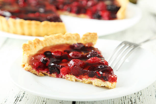 istock Fresh berry tart on plate on white wooden background 472007444