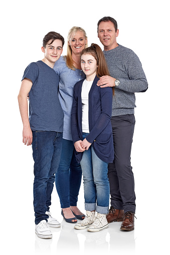Full length portrait of happy caucasian family of four standing together on white background