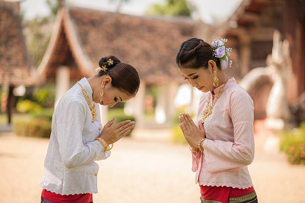 Sawasdee Two Thai women in Sawasdee action. thai traditional costume stock pictures, royalty-free photos & images