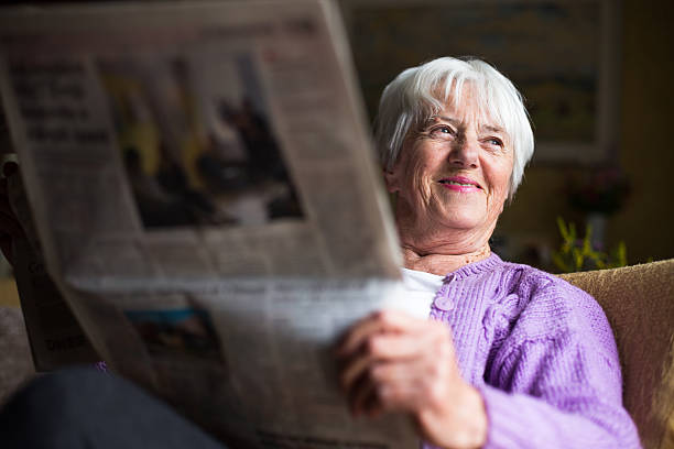Senior woman reading morning newspaper stock photo