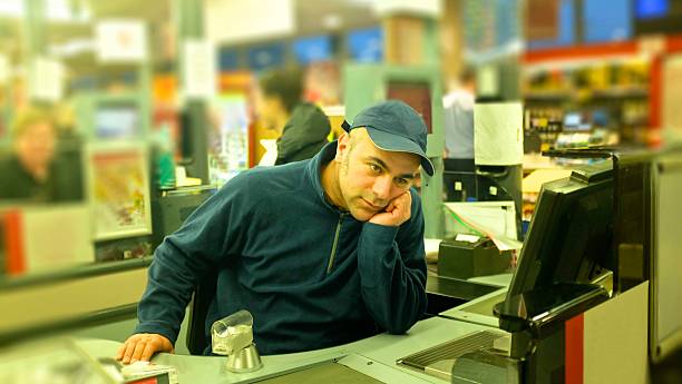 junger lehrling kassierer im supermarkt teilzeit gelangweilt durchdachte - supermarket sales clerk retail cashier stock-fotos und bilder