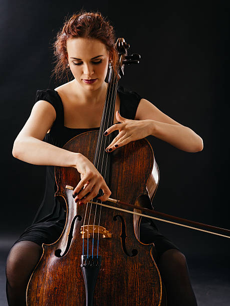 hermosa mujer tocando el violonchelo - musical instrument string music dark old fashioned fotografías e imágenes de stock