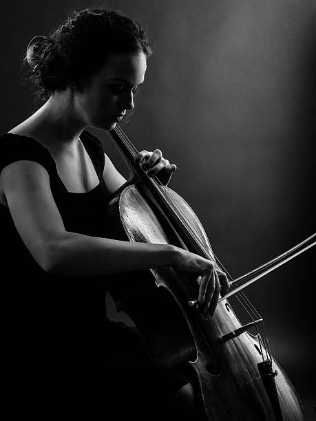 la mujer tocando violonchelo en blanco y negro - musical instrument string music dark old fashioned fotografías e imágenes de stock