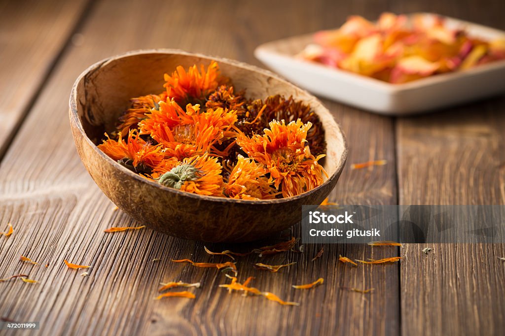 Calendula homeopathic. Homeopathic medicine, calendula dry flowers and wooden surface. Alternative Therapy Stock Photo