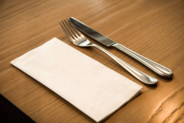 istock Fork, knife and paper napkin on a wooden table. 472013794