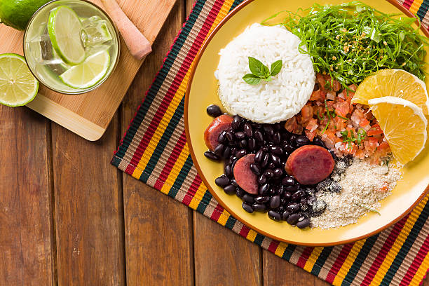 Yellow plate of feijoada with rice and margarita with lime