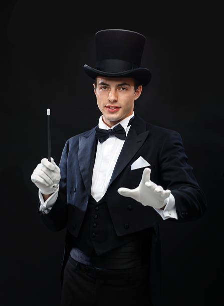 istock magician in top hat with magic wand showing trick 472013843