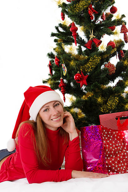 istock Woman in red lying under Christmas tree with gifts 472015775