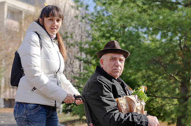 istock Carer helping a man in  wheelchair 472017267