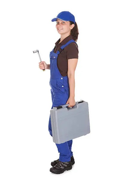 Happy young female technician holding toolkit on white background