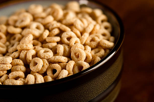 Bowl Of Cereal This is a shot of a bowl full of cereal shot on a brown background with a shallow depth of field. Cheerios stock pictures, royalty-free photos & images