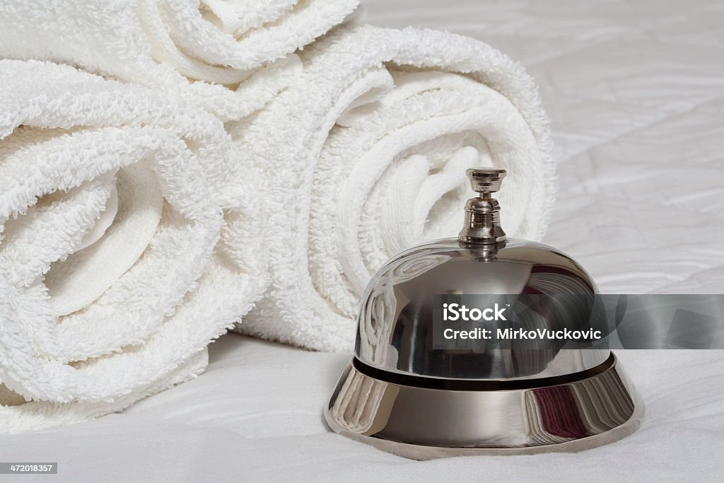 Room service bell and rolled towels Service bell and rolled towels on bed A Helping Hand Stock Photo