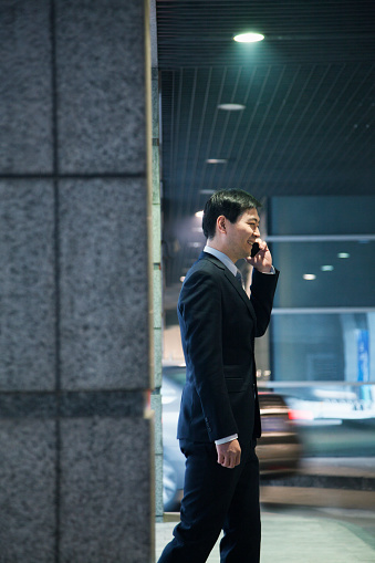 Businessman talking on the phone in a parking garage