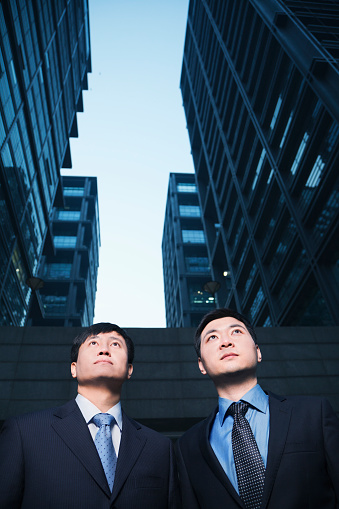 Two businessmen standing side by side outdoors, Beijing