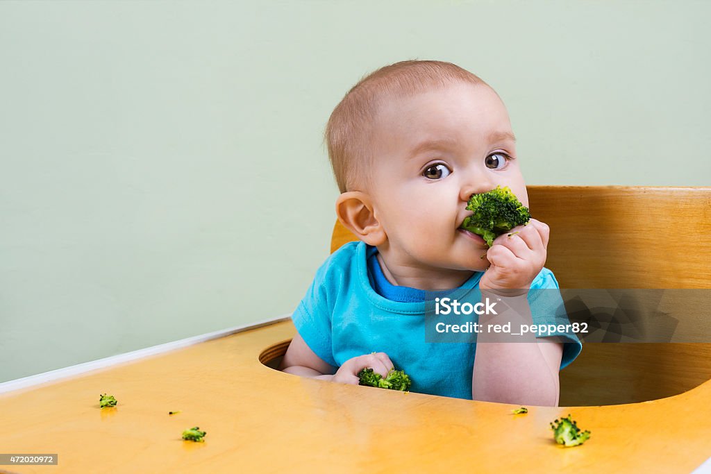 Hermoso bebé comer broccoli - Foto de stock de Comer libre de derechos
