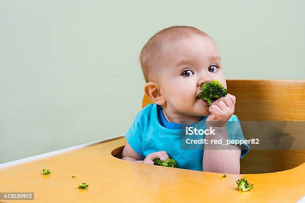 Hermoso Bebé Comer Broccoli Foto de stock y más banco de imágenes de Comer - Comer, Bebé, Brécol