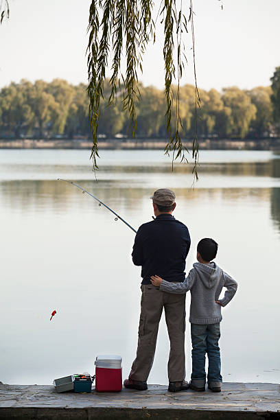 avô e neto pescaria ao lado da doca no lago - fishing lake grandfather grandson - fotografias e filmes do acervo