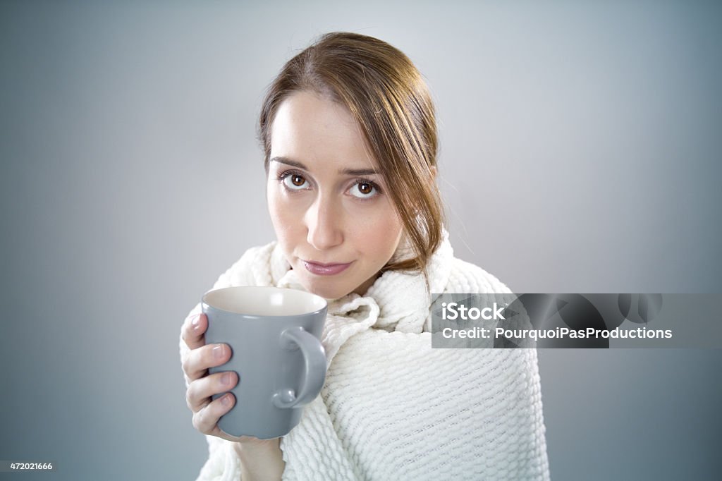 Sick woman Portrait of a sick woman in a coverage with a tea. 2015 Stock Photo