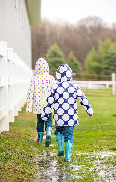 istock Two Young Girls Walking in Rain on the Ranch 472024208