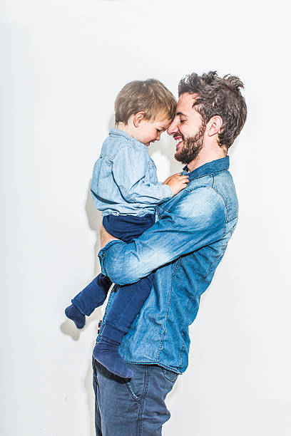 Father and son Photo portrait of father and son. Smiling father holding his son in the arms. fashionable dad stock pictures, royalty-free photos & images