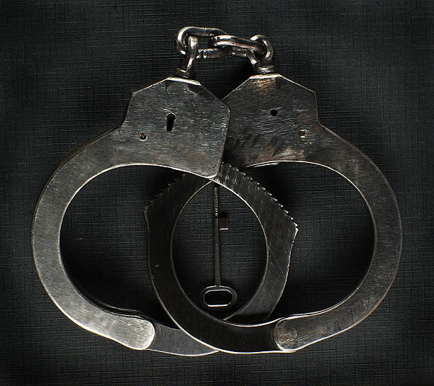 Steel police handcuffs with the key. stock photo