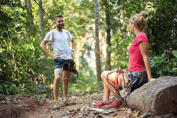 alegre casal desfrutando de tirolesa na floresta tropical - zip lining - fotografias e filmes do acervo