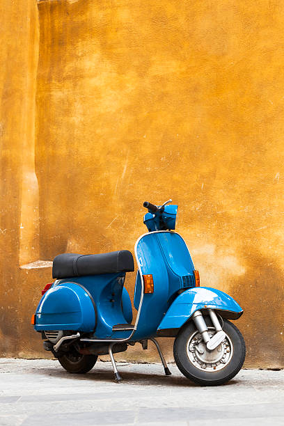 classic azul scooter contra amarillo grunge wall, toscana, italia - italian culture wall italy ancient fotografías e imágenes de stock