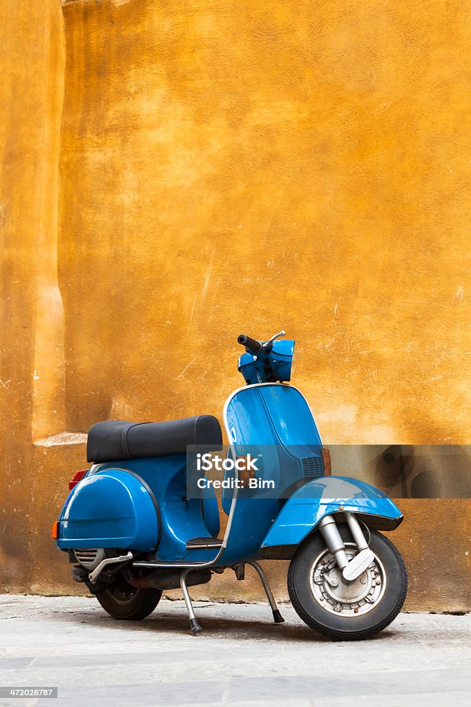 Klasyczny niebieski Grunge Skuter z żółte ściany, Toskania, Włochy - Zbiór zdjęć royalty-free (Skuter z silnikiem)