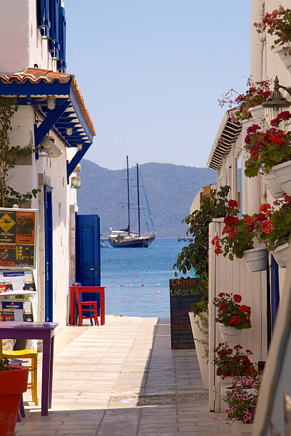 Street opening to sea in Bodrum Bodrum,Turkey-June 23, 2011 : A view of the street with flowers, opening to Aegean Sea in Bodrum. bodrum stock pictures, royalty-free photos & images