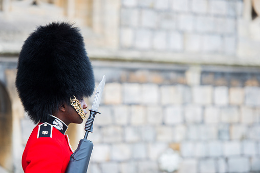 Windsor, United Kingdom - September, 28, 2013: A member of the British Army in a traditional uniform stands guard outside Windsor Castle.