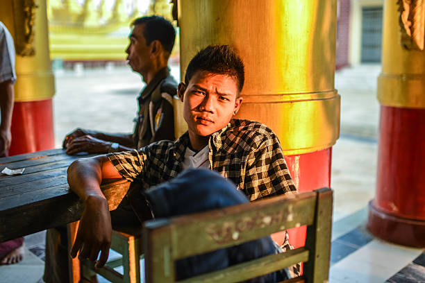 Yangon, Myanmar - February 23, 2013: A young adult was relaxing after his daily work in one pagoda in Yangon, Myanmar.