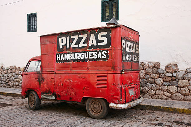 Cuzco, Peru - June 1, 2013: Battered red volkswagen converted into pizza van on Cuzco cobblestoned street