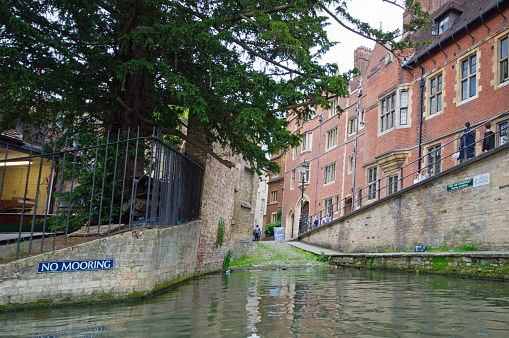 Cambridge, United Kingdom - June 16, 2013: Lazy sunday afternoon on the River Cam in Cambridge, England,tourists looking over railings near a slipway.