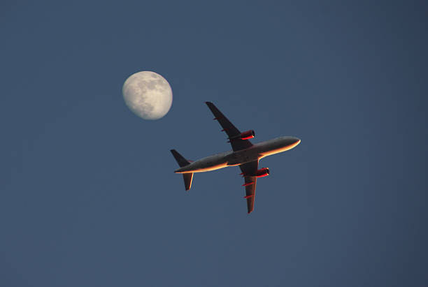 istock Airplane crossing the moon 472031348