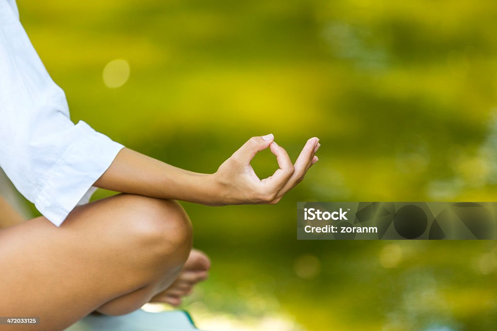 Meditating Woman meditating in lotus position, copy space Adult Stock Photo