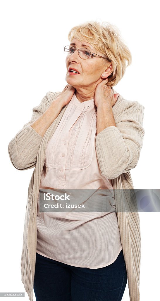 Neck pain Senior woman massaging her neck. Studio shot, white background. Backache Stock Photo