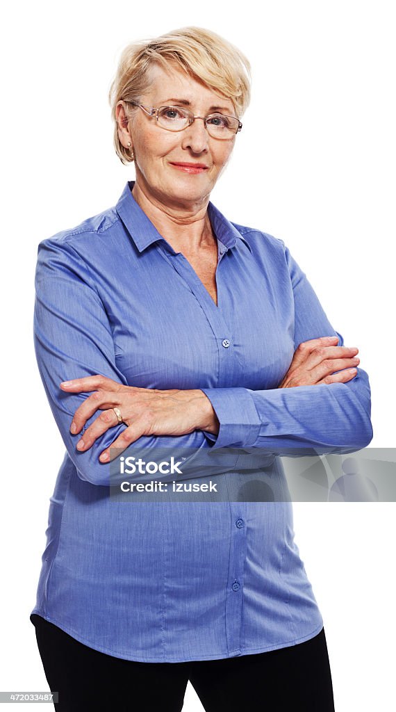 Confident senior woman Portrait of confident senior woman standing with arms crossed and smiling at camera. Studio shot, white background. 60-69 Years Stock Photo